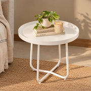 A modern white coffee table made of carbon steel, with a circular shape and three curved legs