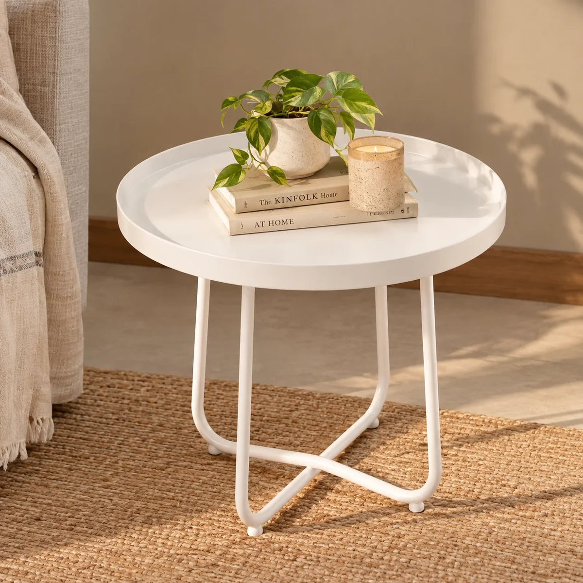 A modern white coffee table made of carbon steel, with a circular shape and three curved legs