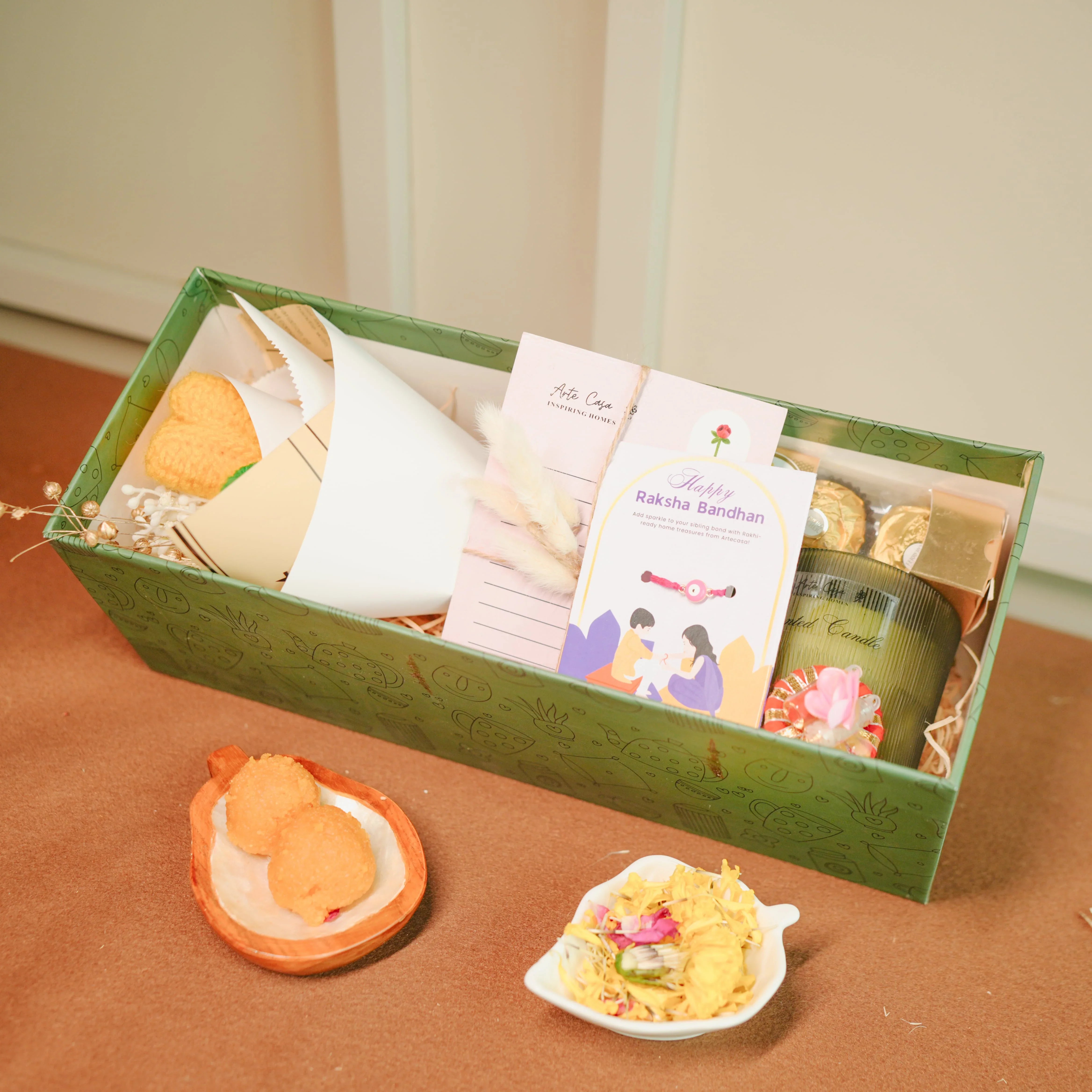 Flower-Themed Rakhi Hamper for Bhai & Bhabhi | Thoughtful Rakhi Gift Set with Candle, Chocolates & Flower Bunch