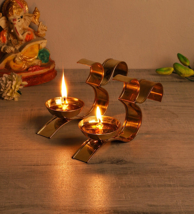Buy Puja Essentials - Om Golden Akhand Diya Set Of 2 | Brass Tealight Holder Stand by Amaya Decors on IKIRU online store